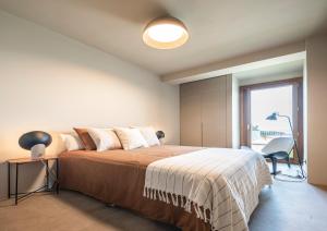 een slaapkamer met een groot bed en een raam bij INSUA BEACH HOUSE in Pontevedra