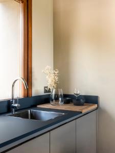 a kitchen counter with a sink and two wine glasses at INSUA BEACH HOUSE in Pontevedra