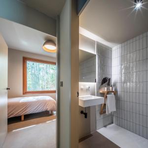 a bathroom with a sink and a bedroom at INSUA BEACH HOUSE in Pontevedra