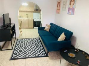 穆兹罗斯Jimmy's Crib的客厅里有一张蓝色的沙发和一张桌子