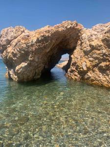 an arch in a rock formation in the water at Jimmy's Crib in Moudhros