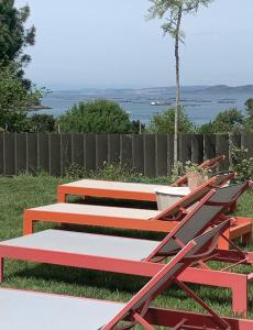a group of benches sitting on the grass at INSUA BEACH HOUSE in Pontevedra