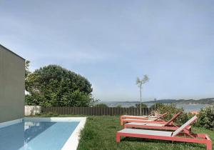 a row of chairs sitting next to a swimming pool at INSUA BEACH HOUSE in Pontevedra