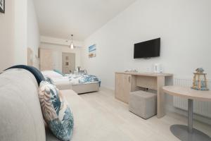 a bedroom with a bed and a table and a tv at Apartament LENA Dziwnówek nad morzem in Dziwnówek
