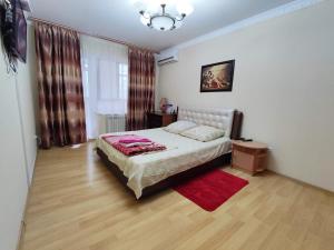 a bedroom with a bed and a red rug at Квартира на Пентагоне in Bender