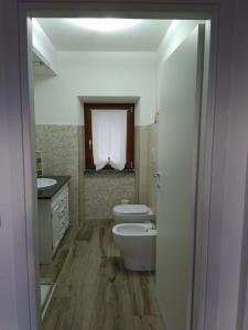 La salle de bains est pourvue de toilettes, d'un lavabo et d'une baignoire. dans l'établissement Podere 660 appartamento il Salice, à Marrucheto