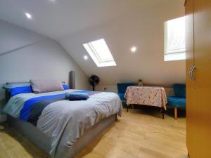 a bedroom with a bed and a table and windows at Comfy Friendly Stay in London