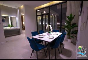 uma sala de jantar com uma mesa e cadeiras azuis em شاليهات حكاية الفندفية em Al Harazat