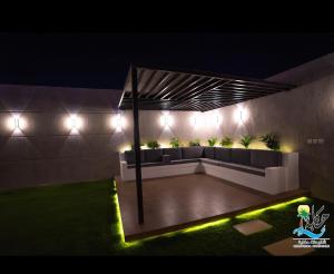 une terrasse avec des canapés et des lumières la nuit dans l'établissement شاليهات حكاية الفندفية, à Al Harazat