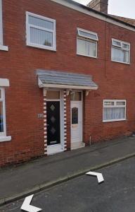 a red brick building with a white door and a white door at A lovely 3 bedroom family house! in Seaham