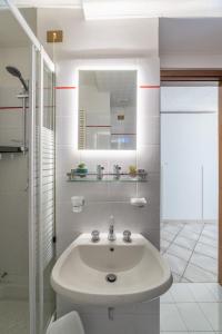 a white bathroom with a sink and a mirror at Centro storico · Leonardo House in Bergamo