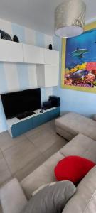 uma sala de estar com um sofá e uma televisão de ecrã plano em Residence Jesolo Lido centro con piscina em Lido di Jesolo