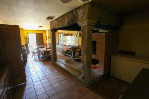 a kitchen with a brick fireplace in a room at Espectacular Casa con Piscina en Allariz in Allariz