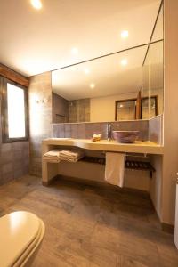 baño con lavabo y espejo grande en Hotel Tulmas en Tilcara