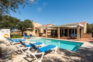 una piscina con tumbonas y una casa en Villa Menorca Flomertor 2 by Mauter Villas, en Cala en Blanes