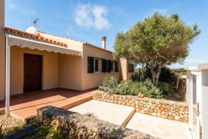 uma casa com uma parede de pedra ao lado de um quintal em Villa Menorca Flomertor 2 by Mauter Villas em Cala en Blanes