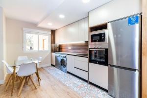 a kitchen with a table and a stainless steel refrigerator at Modern Apartment close to the city center and Alhambra in Granada