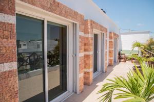 a balcony with sliding glass doors on a brick building at Departamento con alberca privada in Chetumal