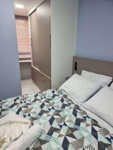 a bedroom with a bed with a quilt on it at Loft no Cond. Mata Atlântica in Volta Redonda