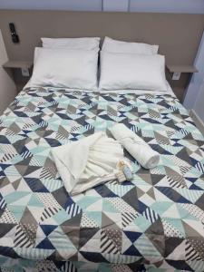 łóżko z kołdrą i poduszkami w obiekcie Loft no Cond. Mata Atlântica w mieście Volta Redonda