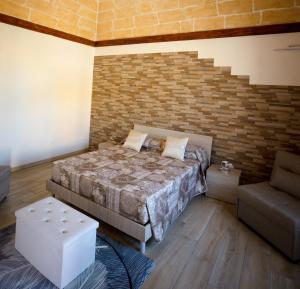 a bedroom with a bed and a chair in it at Casa Vacanza Patrizia in Marsala