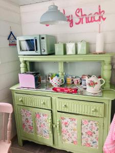 a green cabinet with a microwave on top of it at Shabby Shack near Charlestown & The Eden Project in St Austell