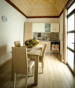 a dining room with a table and chairs and a kitchen at Casa Vacanza Patrizia in Marsala