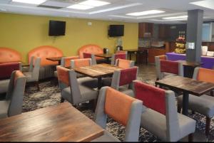 a dining room with tables and chairs and televisions at Eldorado Atlantic City Beach Block in Atlantic City