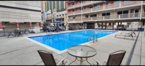 a swimming pool with a table and chairs in a building at Eldorado Atlantic City Beach Block in Atlantic City