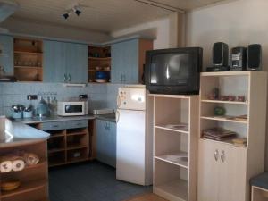 uma cozinha com um pequeno frigorífico e uma televisão em Hostinec Banik em ľubeľa