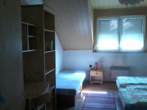 a small bedroom with a bed and a window at Hostinec Banik in ľubeľa