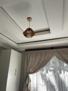 techo con lámpara de araña y ventana con cortinas en Yello guest house, en Vanderbijlpark