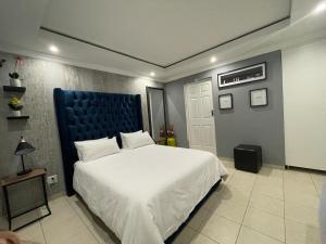 a bedroom with a large bed with a blue headboard at Yello guest house in Vanderbijlpark +25 photos