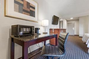 a hotel room with a desk with a microwave at Heritage Inn Express Hayward in Hayward