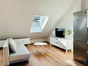 a living room with a couch and a tv at Ruheoase - Premium Suite in Karlsruhe