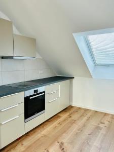 a kitchen with white cabinets and a skylight at Ruheoase - Premium Suite in Karlsruhe