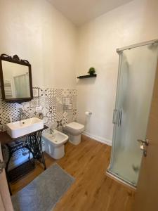 La salle de bains est pourvue d'un lavabo, de toilettes et d'un miroir. dans l'établissement Camera via Roma, à Follonica