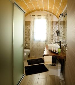 bagno con lavandino, servizi igienici e finestra di Casa Vacanza Patrizia a Marsala
