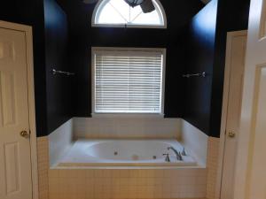 La salle de bains est pourvue d'une baignoire et d'une fenêtre. dans l'établissement Stone Mountain Cozy Home, à Snellville