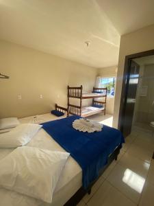 a bedroom with two twin beds and a balcony at Pousada Parque Central in Penha