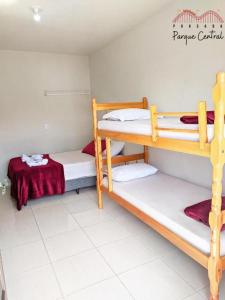 a dorm room with three bunk beds in it at Pousada Parque Central in Penha