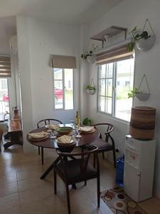uma sala de jantar com uma mesa e cadeiras numa cozinha em The Boho-Chic Staycation House em Dao