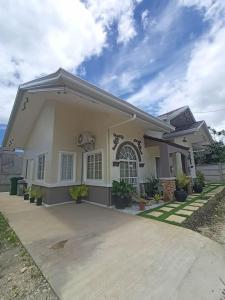 uma pequena casa branca com um alpendre em The Boho-Chic Staycation House em Dao