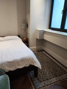 a bedroom with a bed and a window at Beautiful maisonnette flat in Islington in London