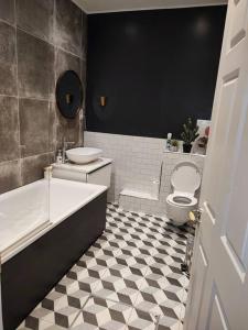a bathroom with a tub and a toilet and a sink at Beautiful maisonnette flat in Islington in London