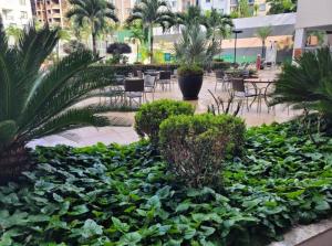 a garden with green plants and tables and chairs at Veredas do Rio Quente Hotel Service in Rio Quente