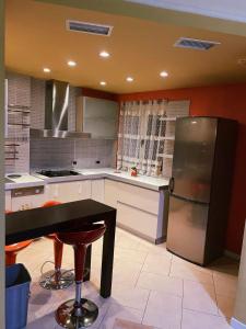 a kitchen with a refrigerator and a table in it at Sunshine Place in Elbasan