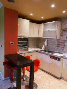 a kitchen with a black table and orange chairs at Sunshine Place in Elbasan