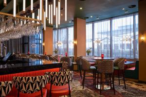 a restaurant with tables and chairs and chandeliers at Malmaison Liverpool in Liverpool