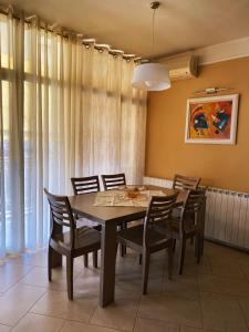 a dining room with a wooden table and chairs at Sunshine Place in Elbasan